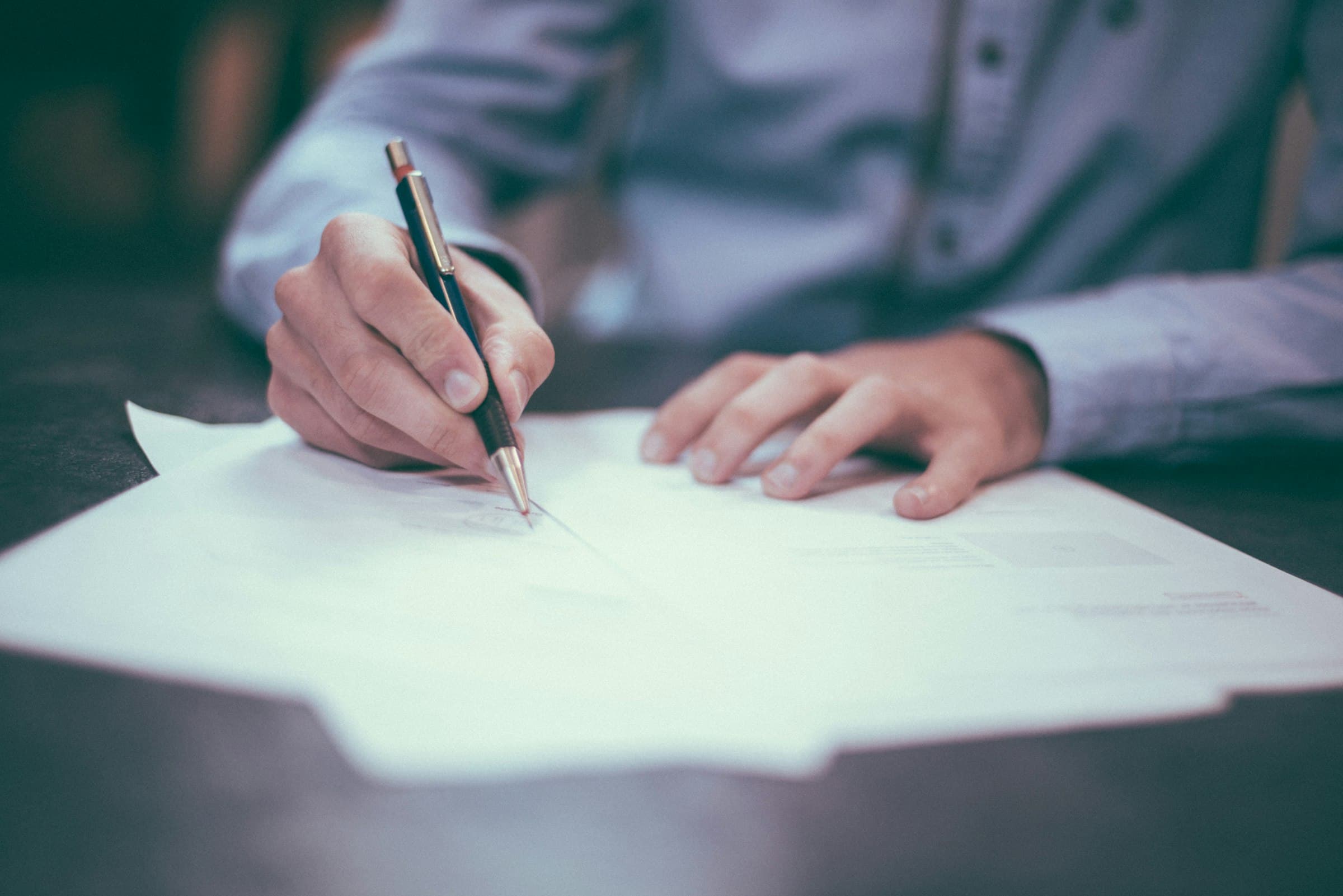 Legal documents and pen on a desk representing property title deeds